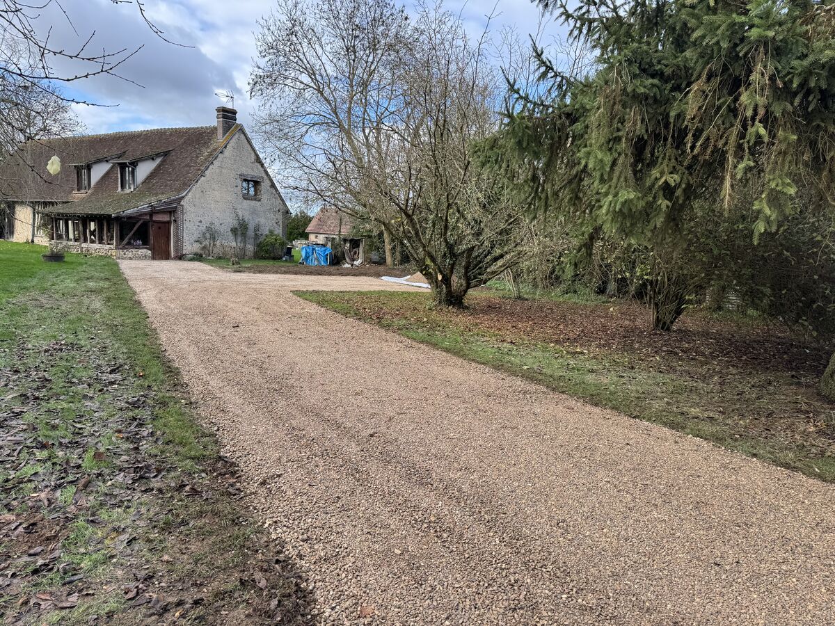 Allée en gravier menant à une maison en pierre