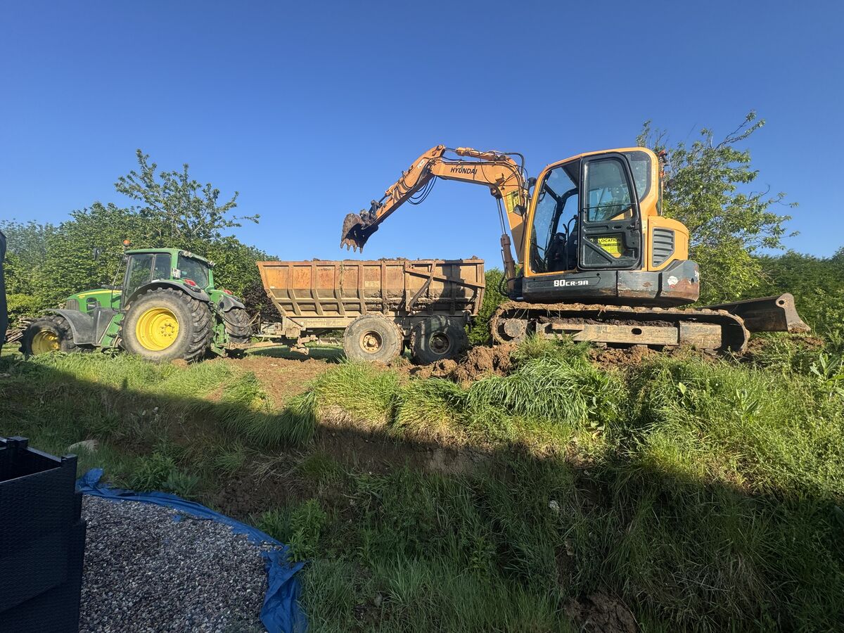 Pelleteuse et tracteur en action sur un chantier de terrassement